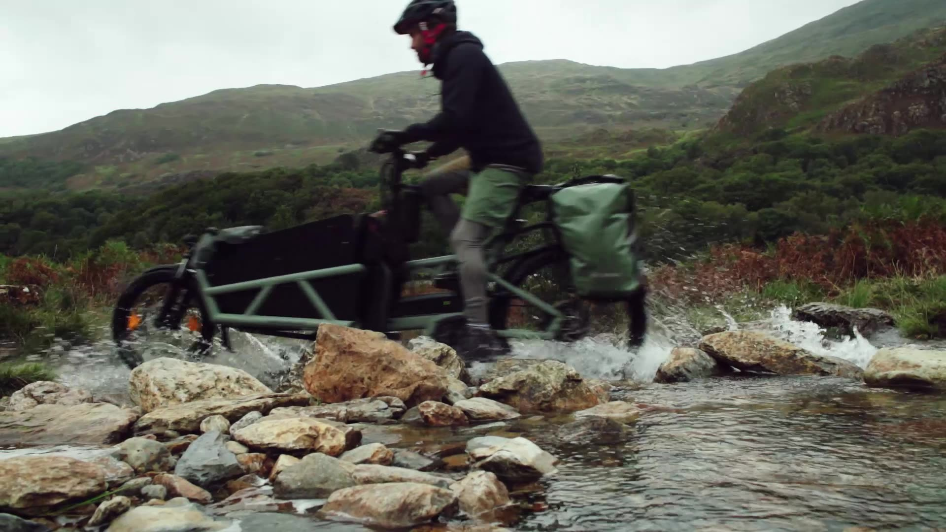 Riese & Müller Load cargo bike crossing a shallow river on an adventure ride