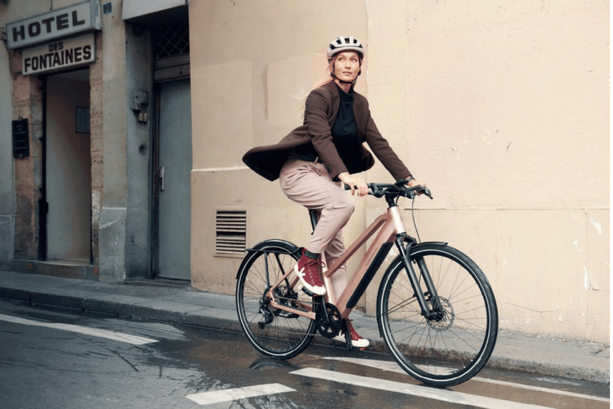 Woman riding an e-bike in a relaxed upright position through a city