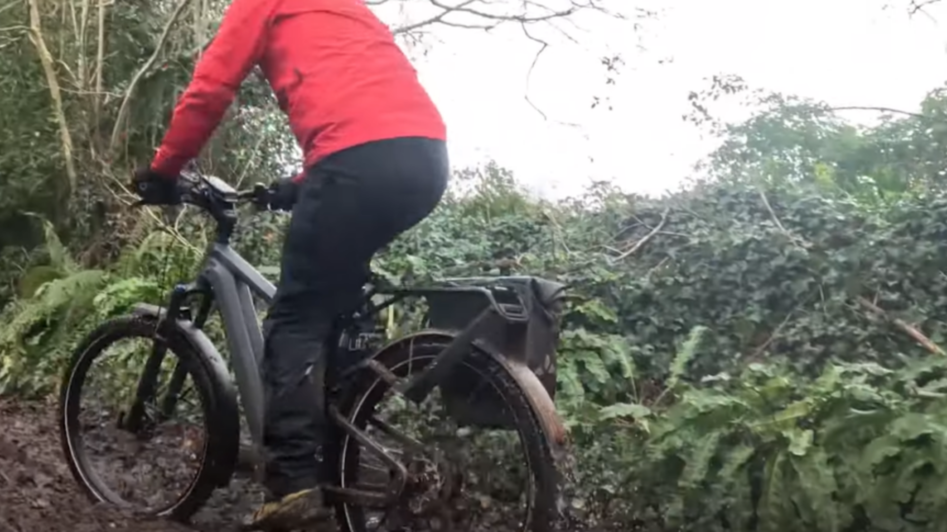 Dan riding through a muddy trail on an e-bike, demonstrating real-world motor performance