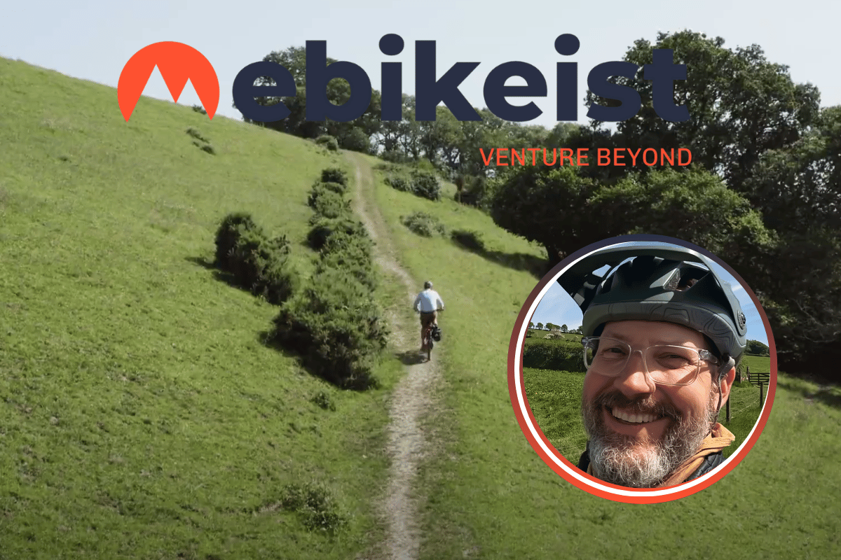 Dan riding up a green hillside with eBikeist logo overlay